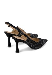 Talons slingbacks en daim noir avec un bout pointu, ornés de rhinestones noirs, présentant un talon moyen cylindrique et une bride de cheville.