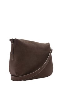Brun suedette skuldertaske med flad form, justerbar rem og sølvfarvet lynlåsdetalje, der har en glat tekstur og minimalistisk design.