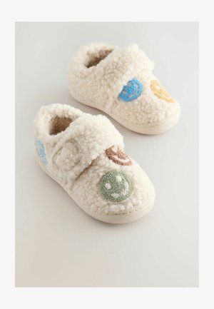 Pantofole bianche e pelose realizzate in tessuto morbido con una cintura in Velcro, decorate con colorati volti sorridenti ricamati in blu, verde, arancione e marrone.