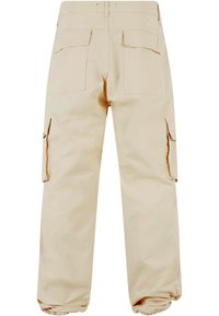 Beige cargobroeken met een losse pasvorm, voorzien van twee zijzakken en twee achterzakken. De stof lijkt duurzaam en de pijpen hebben elastische boorden bij de enkels.