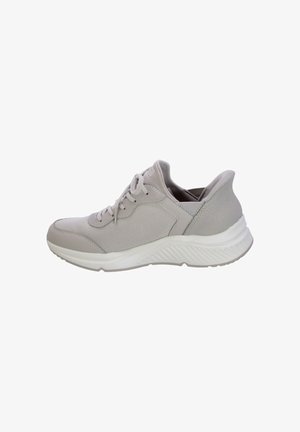Zapatilla deportiva de color gris claro con un cuerpo de malla texturizada, acentos lisos, cordones tradicionales y una suela blanca acolchada con detalles estriados.