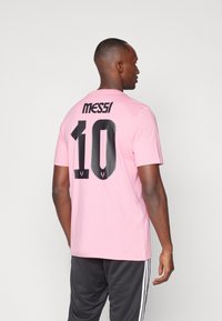 Pink cotton t-shirt featuring a black "Messi" logo and large "10" on the back. Short sleeves, crew neck, relaxed fit.