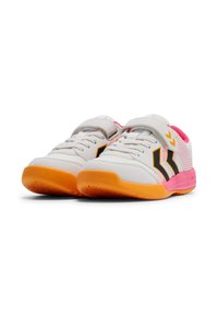 Witte sportschoenen met roze en oranje accenten, textuur bovenkant, klittenbandsluiting en zwart logo. Rubberen zolen met grippatroon.