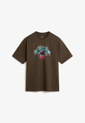 T-shirt in cotone marrone con un vivace design grafico caratterizzato da accenti blu e rosa, che rappresenta un volto di mostro stilizzato e pinne affilate.