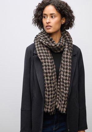Écharpe en mélange de laine avec un motif pied-de-poule noir et beige. Texture douce, bords à franges, portée lâche autour du cou.