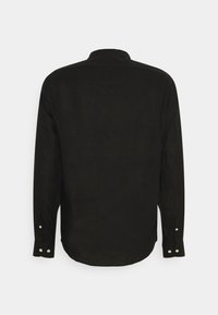 Camicia nera a maniche lunghe in lino, con colletto a punta, polsini con bottoni e orlo curvato sul retro.