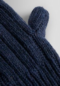 Guanti blu navy lavorati a maglia con texture a coste, dotati di un piccolo anello sul polsino. Realizzati in un morbido e caldo filato.