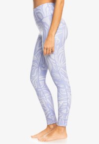 Ljuslila leggings med blommönster, hög midja, elastiskt material och en liten logotyp på vänster underben.