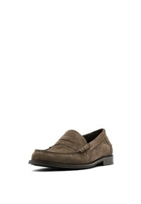 Mocassin homme en daim marron avec un petit talon et des détails cousus à l’avant et sur les côtés, présenté légèrement en angle sur fond blanc.