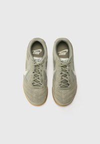 Light green Nike sneakers with suede and mesh materials, featuring a textured surface, rubber sole, and signature branding on the tongue.
