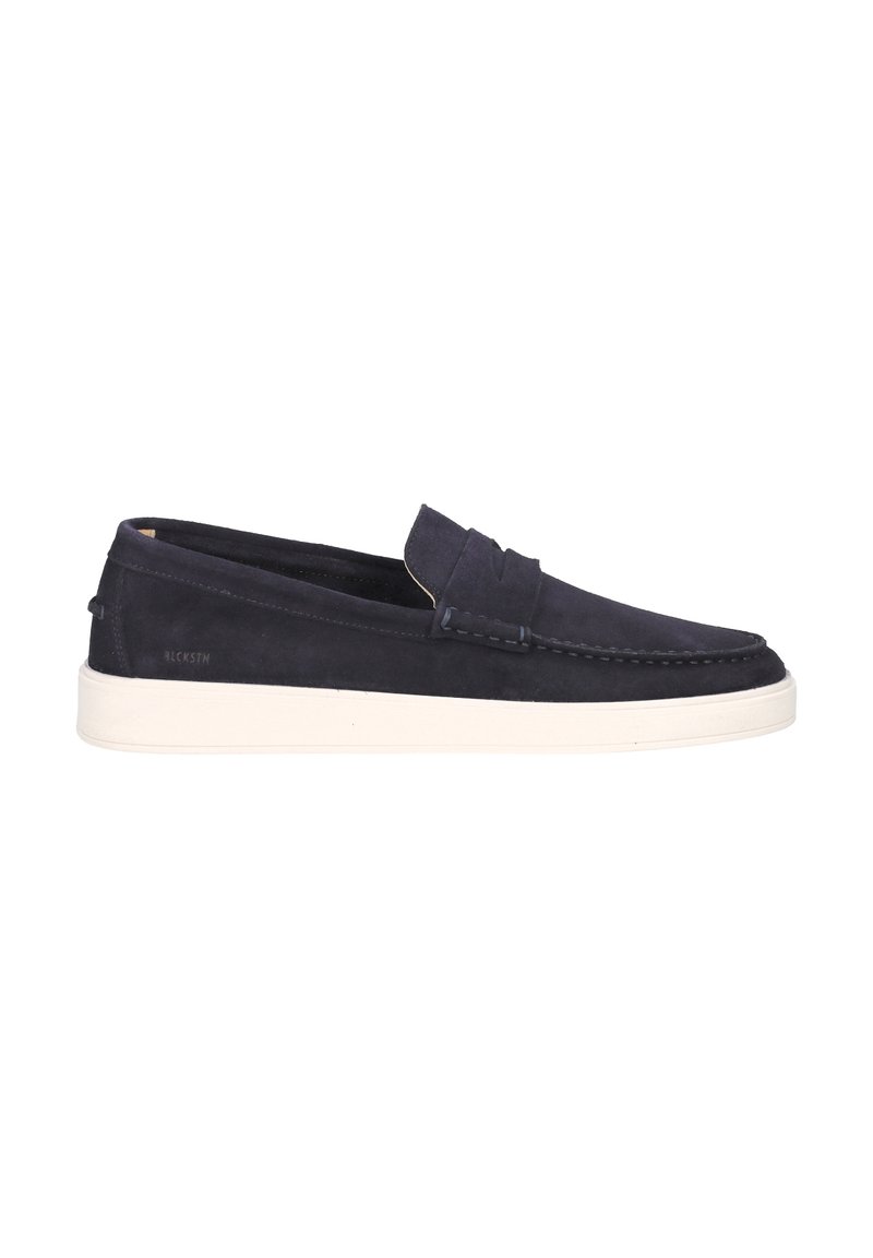 Zapato slip-on de ante azul marino con una textura suave, puntera redondeada, suela de goma blanca en contraste y detalles de costura mínimos en la parte superior.