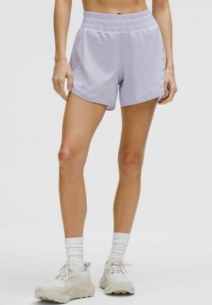 Light purple athletic shorts with an elastic waistband and side pockets, made of smooth, breathable fabric, worn with pale sneakers and white socks.