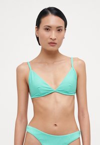 En mintgrønn bikini med ribbet tekstur, trekantede kopper og tynne justerbare stropper. Underdelen har et lignende ribbet design.