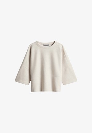 Pull ample beige avec manches larges trois-quarts, encolure ronde et détail de couture traversant la poitrine et les manches.