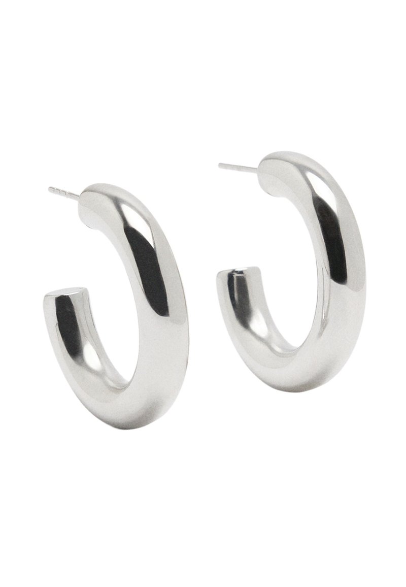 Srebrne kolczyki koła o gładkim, błyszczącym wykończeniu. Zaokrąglony kształt z delikatnym zakrzywieniem i widocznym sztyftem do zapięcia.