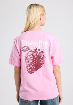 Roze katoenen t-shirt met een grote aardbeienafbeelding in donkerrood en witte tekst "Proef het Seizoen" op de achterkant.