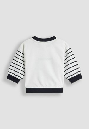 Valge dressipluus tumesiniste triibuliste varrukatega. Omab soonikkude krae ja mansetid, koos volangiga vöökoht, et saavutada vormitud välimus.