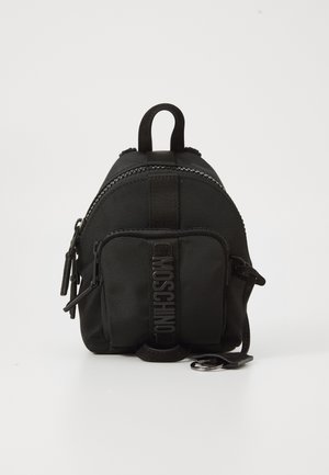 Sac à dos noir en nylon de forme arrondie, avec un compartiment principal zippé, une poche avant et un logo en relief sur la sangle. Deux poignées supérieures.