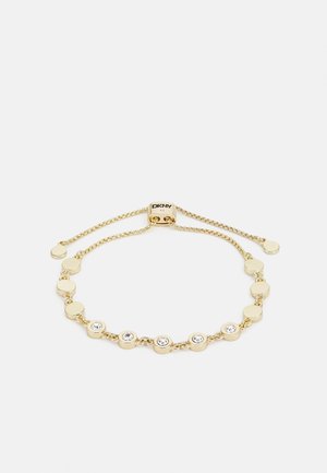 Gold-tone adjustable chain bracelet with circular crystal accents and a sliding clasp engraved with "DKNY."