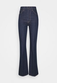 Jeans svasati blu scuro realizzati in denim. Design a vita alta con cinque tasche, cuciture dettagliate e una parte superiore aderente che sfocia in una gamba ampia.