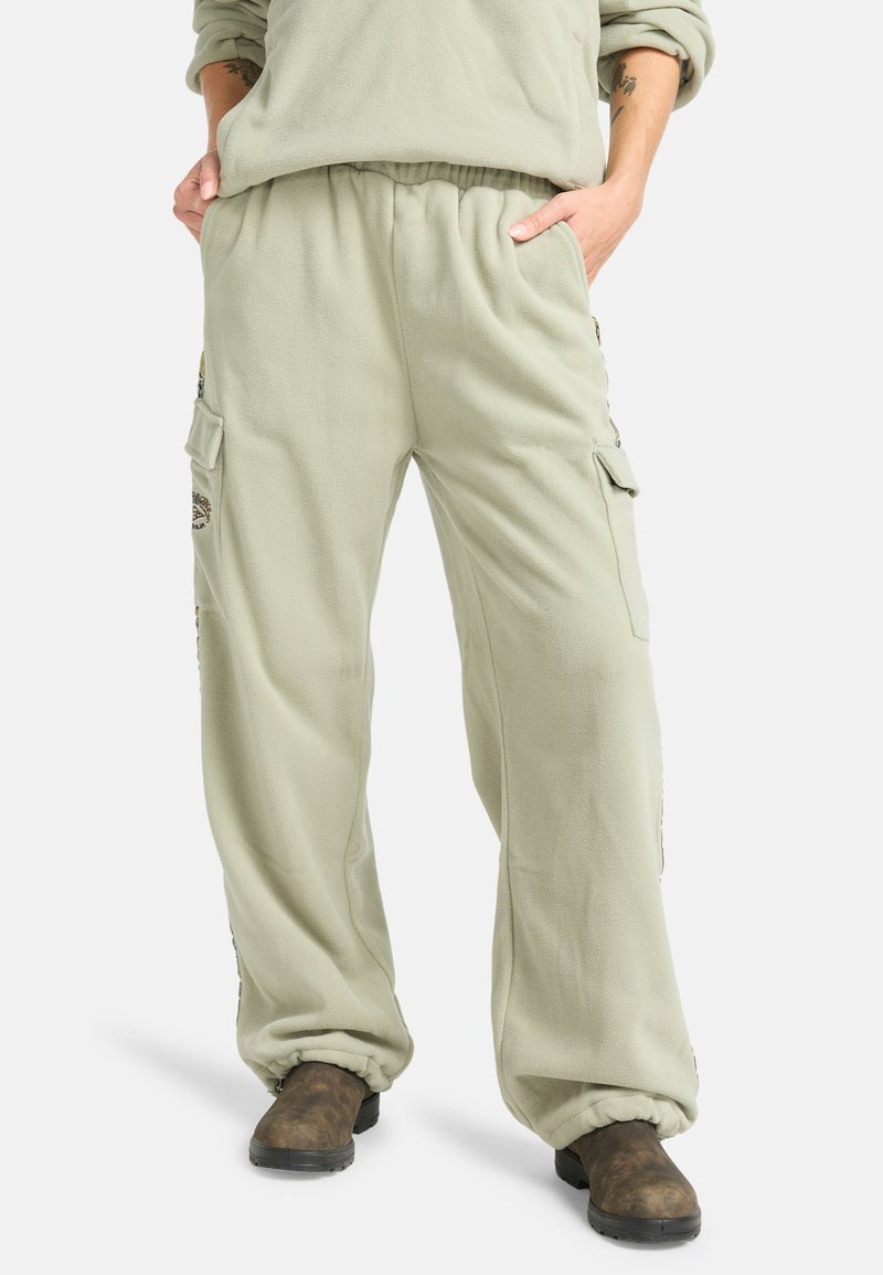 Lichtgroene fleece cargobroek met een elastische tailleband, zijzakken en subtiele borduurdetails aan de zijkanten; ontspannen pasvorm.