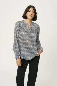 Camicia a maniche lunghe nera e bianca con un design a fantasia di foglie, caratterizzata da un collo a v e una vestibilità rilassata. Abbinata a pantaloni neri.