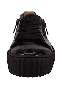 Baskets en cuir verni noir avec une semelle en caoutchouc noir texturé, dotées de lacets plats et de détails zippés sur les côtés.