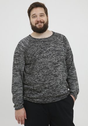 Sudadera de punto en tonos gris y negro jaspeados, con mangas largas y cuello redondo, que presenta un ajuste relajado y una tela texturizada.