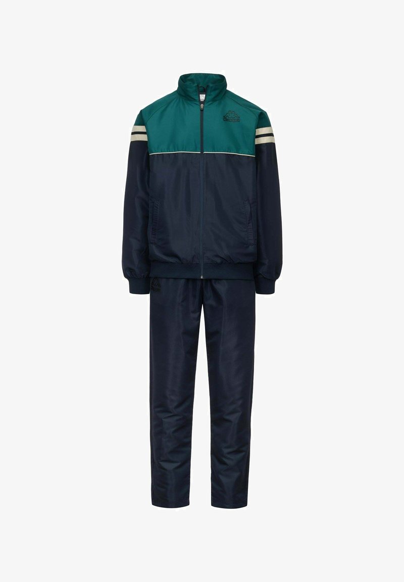 Tuta navy con un design a blocchi di colore teal e crema, composta da una giacca con zip e pantaloni coordinati, realizzata in materiale leggero e liscio.