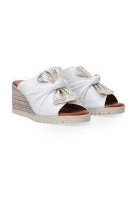 Witte wedge sandalen met een gedraaide strikdetail versierd met metalen accenten, met een textuurhak en een open teen ontwerp.