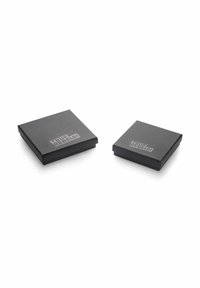 Dos cajas cuadradas y negras con una textura suave, que presentan un logo plateado "TRUE REBELS!" en la superficie superior. Diseño compacto para almacenamiento.