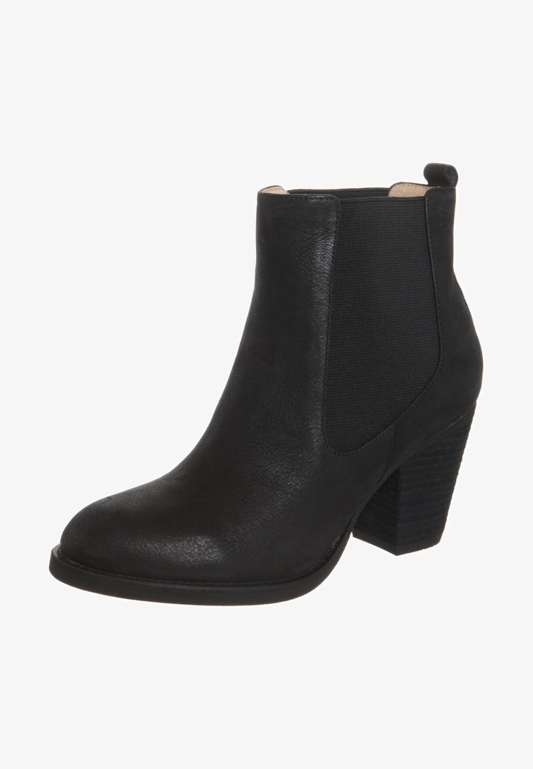 Bottine en cuir noir avec talon bloc empilé, panneau latéral élastique et languette à l'arrière.