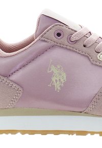 Helle rosa Sneaker mit einem glatten Obermaterial aus synthetischem Material, Wildlederakzenten und einer strukturierten Sohle. Auf der Seite befindet sich ein goldenes Logo eines Polo-Spielers.