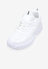 Scarpa sportiva bianca con tomaia in mesh, suola in gomma testurizzata e accenti scuri a contrasto. Presenta lacci e collo imbottito per il comfort.