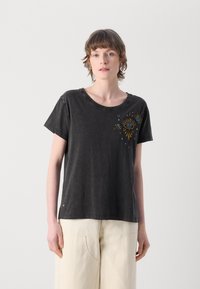 T-shirt nera a maniche corte realizzata in tessuto morbido, con motivo a occhi multicolore e design a raggiera sul lato sinistro.