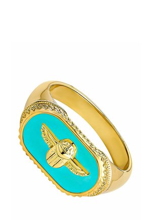 Anillo de oro con una cara ovalada de color turquesa con un escarabajo de oro en relieve con alas extendidas en el centro.
