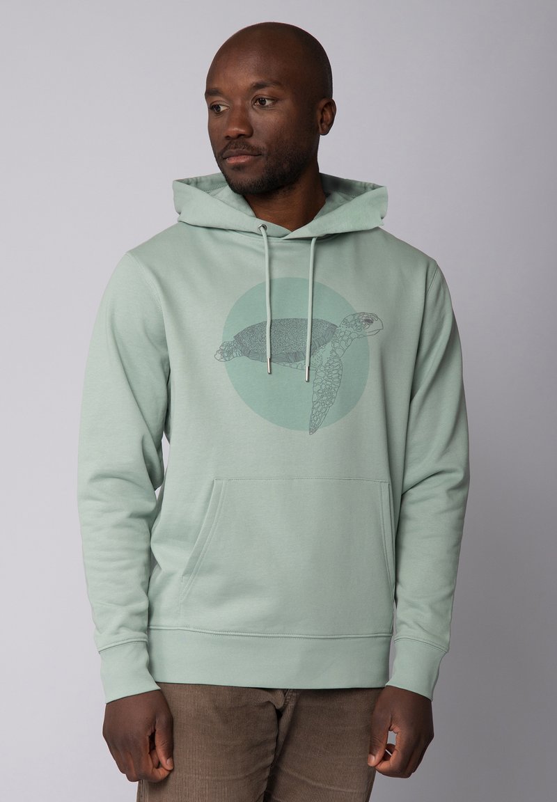 Mintgrüner Hoodie aus weichem Material, mit einem Schildkrötengrafik in der Mitte und einer Kängurutasche auf der Vorderseite.