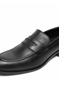 Svarta läderloafers med en slät yta, rund tå och dekorativt remakcent. Standard platt klack och minimal sömnadsdetalj.