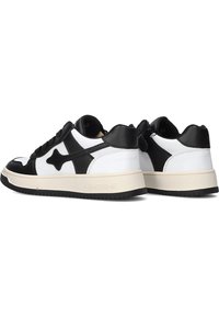 Zwart-witte sneakers van leer met een gladde afwerking. Voorzien van een dikke witte zool en een prominent sterlogo aan de zijkant.