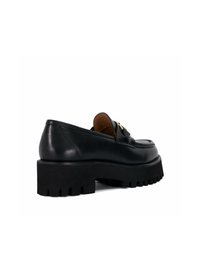 Zwarte leren loafers met een dikke, gestructureerde zool, voorzien van gestikte details en een decoratieve metalen accenton de voorkant.