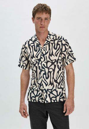 Korte mouwen shirt van crèmekleurige stof met een gedurfde zwarte abstracte print, met knopen aan de voorkant en een relaxte pasvorm.