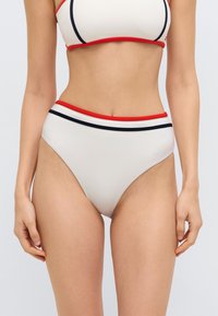 Ψηλόμεσο κάτω μέρος μπικίνι σε κρεμ απόχρωση, με αντιθετικές στενές κόκκινες και ναυτικές ρίγες κατά μήκος της μέσης. Λείο, ελαστικό υλικό.