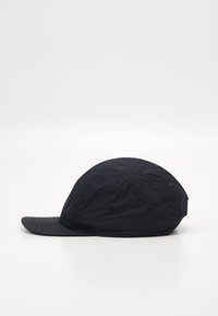 Black cap made of lightweight fabric, featuring a curved brim, stitched seams, and ventilation eyelets on the sides.