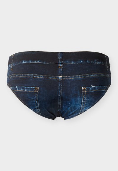 Sous-vêtements bleu foncé conçus pour ressembler à un jean en denim, avec poches arrière et détails de couture sur un fond uni.