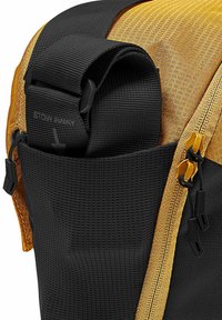 Zwarte en gouden rugzak met een gestructureerde stof, voorzien van een ritsvak, verstelbare schouderbanden en een opvallende gele accent nabij de bovenkant.