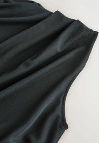 Czarny top na ramiączkach wykonany z gładkiego, elastycznego materiału. Charakteryzuje się miękkim drapowaniem oraz prostym bezrękawnikowym krojem z okrągłym dekoltem.