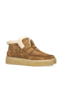 Brown suede mid-top shoes with a fluffy white lining, featuring a rounded toe, stitching details, and a textured sole.
