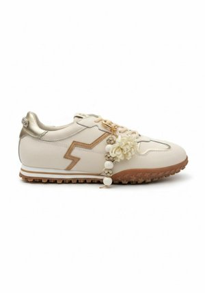 Crème- en beige sneaker met bruine zigzagdetails, een gestructureerde zool en decoratieve kralen en een bloemenbedel bevestigd aan de veters.