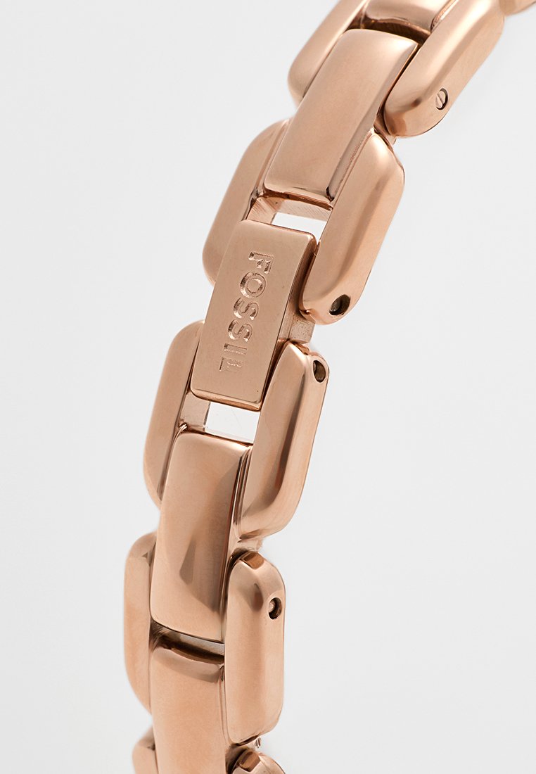 Bracciale in metallo rose gold con maglie rettangolari, superficie lucida e logo "Fossil" inciso su una maglia.