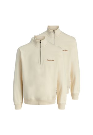 Sweat-shirts zippés demi-zip en crème clair, fabriqués en tissu doux, avec des poignets et un ourlet côtelé, arborant un petit logo brodé marron sur la poitrine.